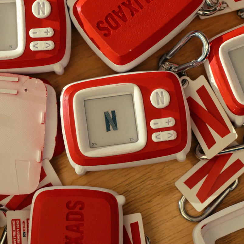 Netflix Charms: red and white retro-TV-shaped keychains, one showing the Netflix N